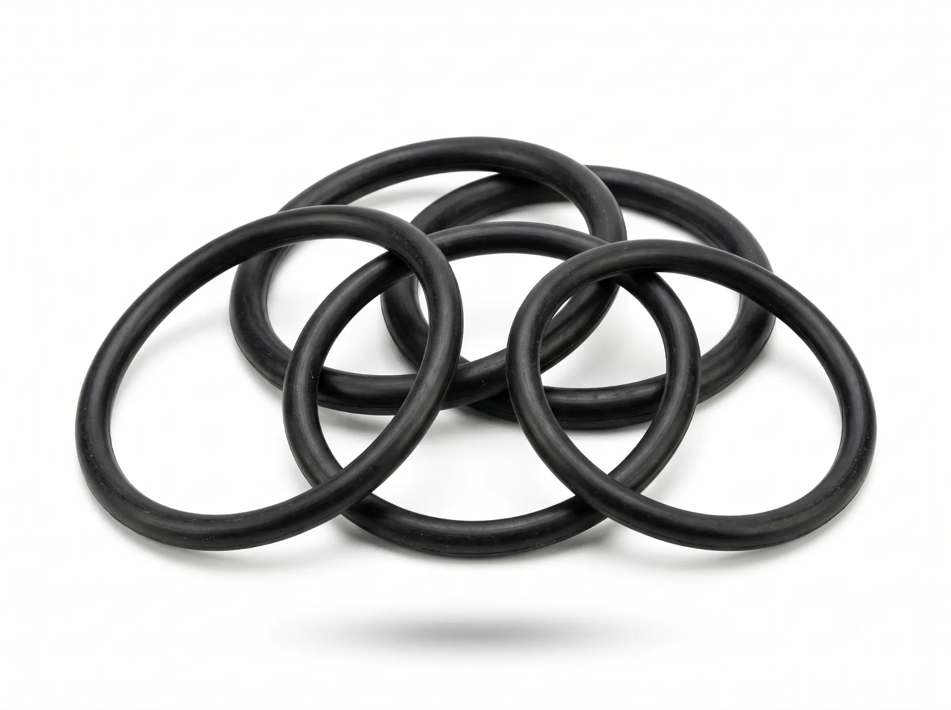 Set of black rubber O-rings stacked on a white background